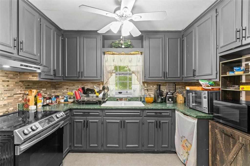 1122 Ridgeleigh Circle Dalton, GA 30720 - Photo 15 of 36 a kitchen with kitchen island granite countertop a sink cabinets stainless steel appliances and a window