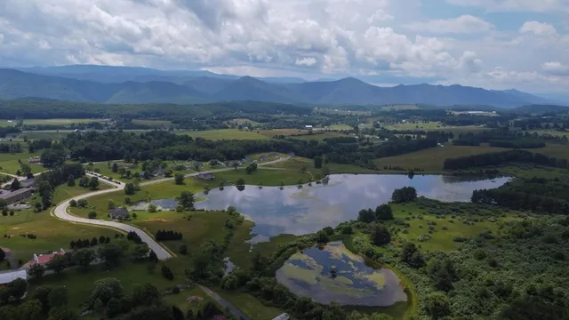 an aerial view of a houses with outdoor space and lake view