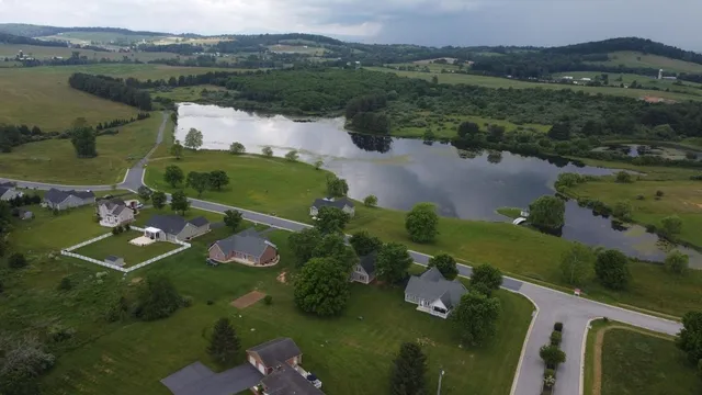 an aerial view of a house with a garden and lake view