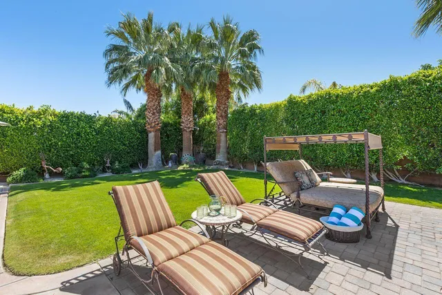 a view of a patio with couches chairs and a table and potted plants