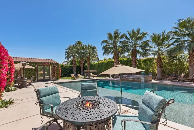 a patio with a table and chairs under an umbrella