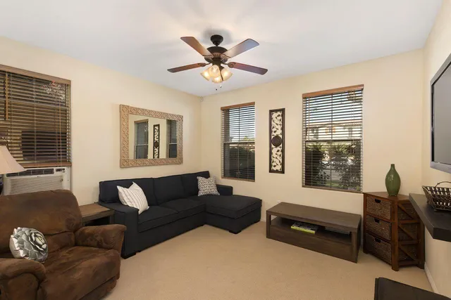 a living room with furniture ceiling fan and a window