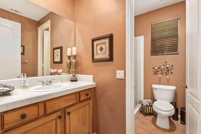 a bathroom with a toilet sink vanity and mirror