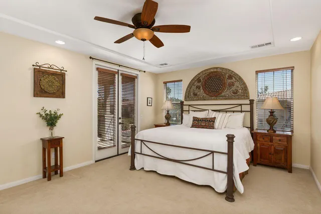a bedroom with a bed a chandelier and a window