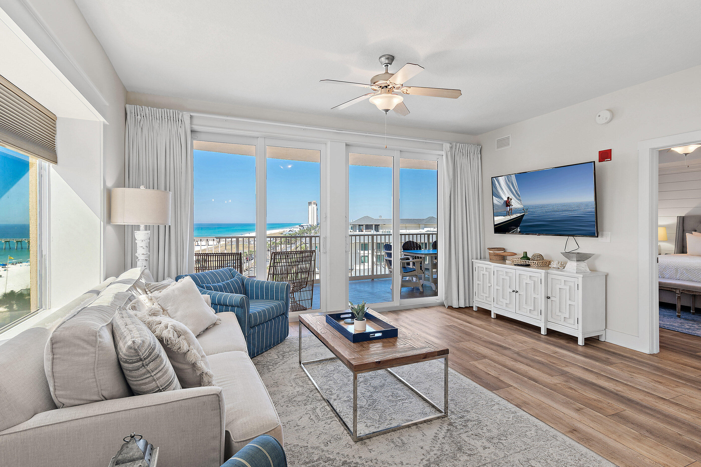 15928 Front Beach Road, Unit 601 Panama City Beach, FL 32413 - Photo 6 of 39 a living room with furniture a flat screen tv and kitchen view
