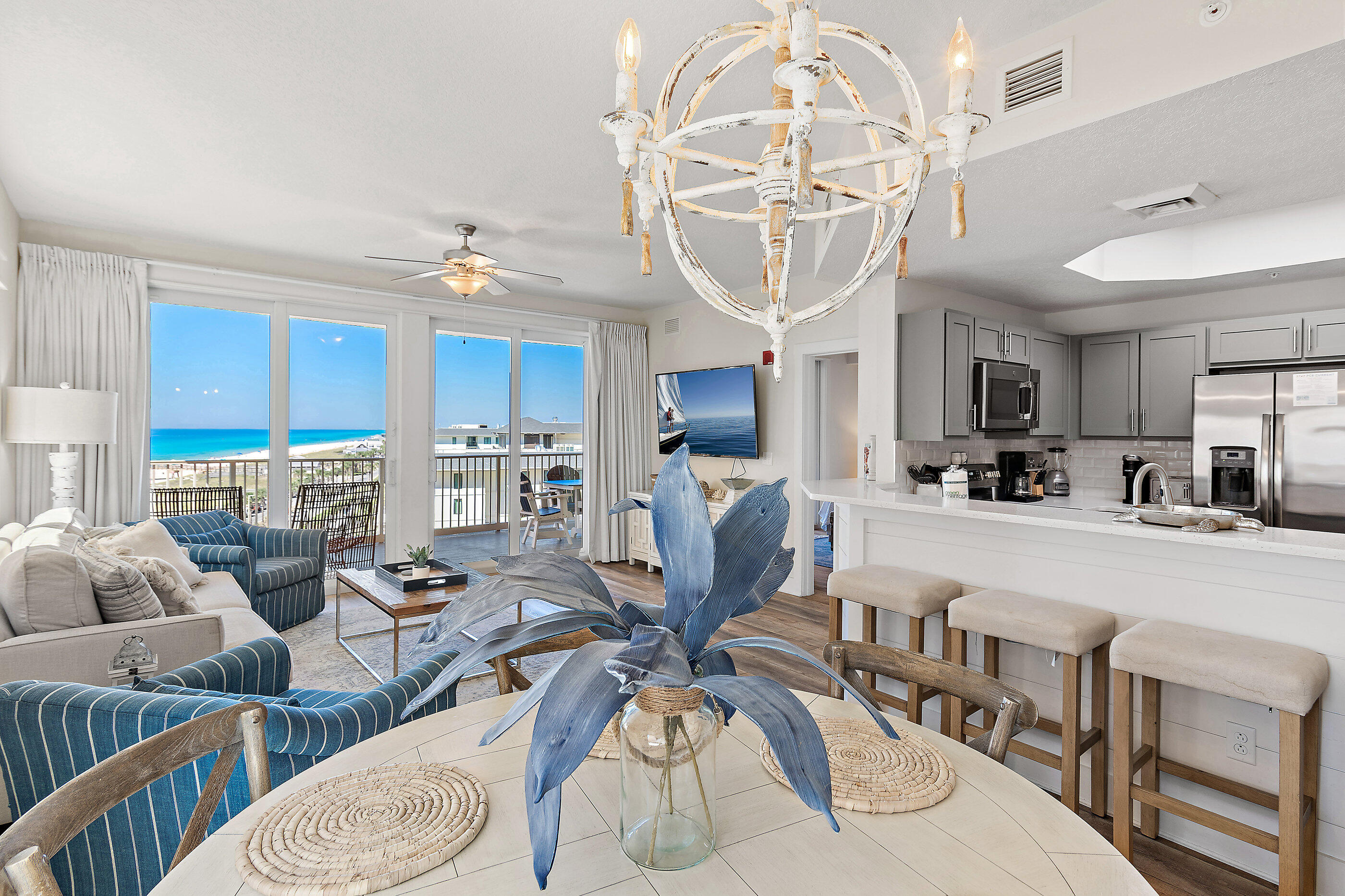 15928 Front Beach Road, Unit 601 Panama City Beach, FL 32413 - Photo 8 of 39 a living room with furniture a chandelier and kitchen view