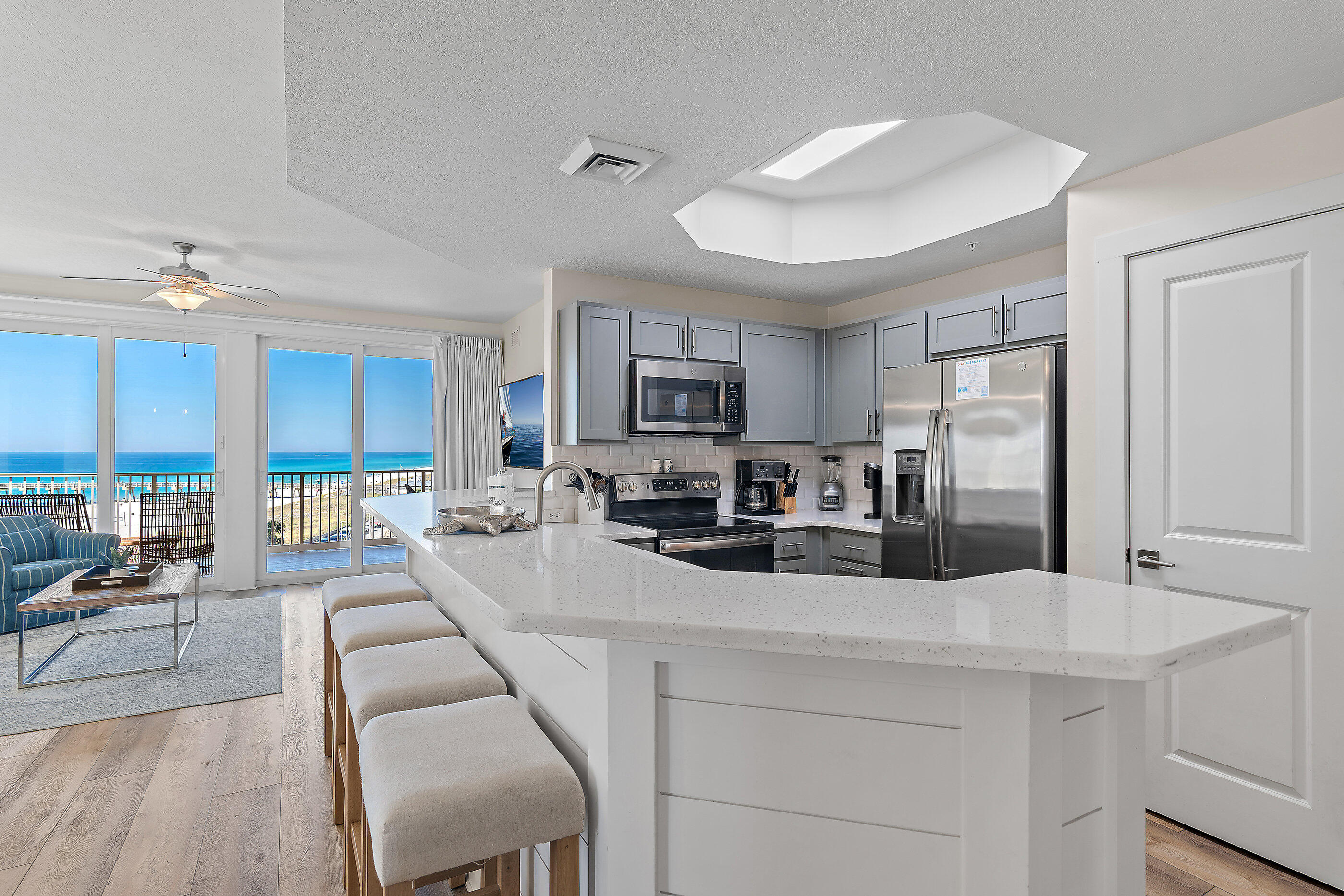 15928 Front Beach Road, Unit 601 Panama City Beach, FL 32413 - Photo 10 of 39 a kitchen with stainless steel appliances granite countertop a refrigerator a stove a sink a dining table and chairs with wooden floor