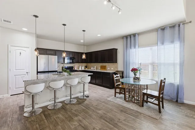 a large kitchen with a table and chairs
