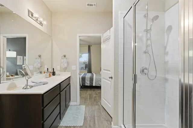 a en suite bathroom with a double vanity sink a mirror and shower