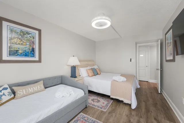 a room with two bed and a painting on the wall