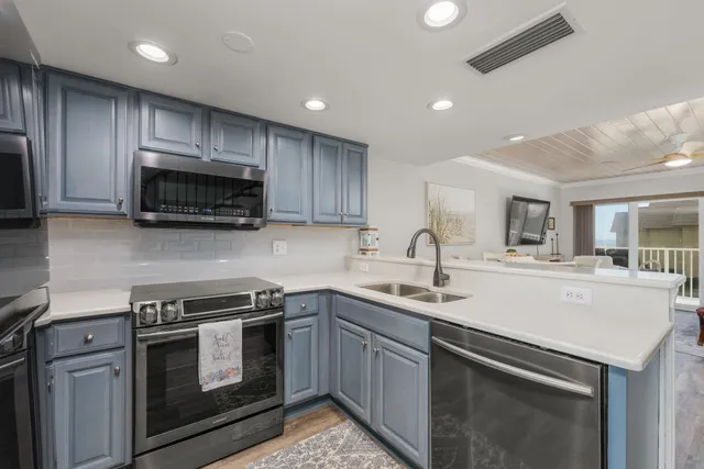 a kitchen with a sink and steel appliances