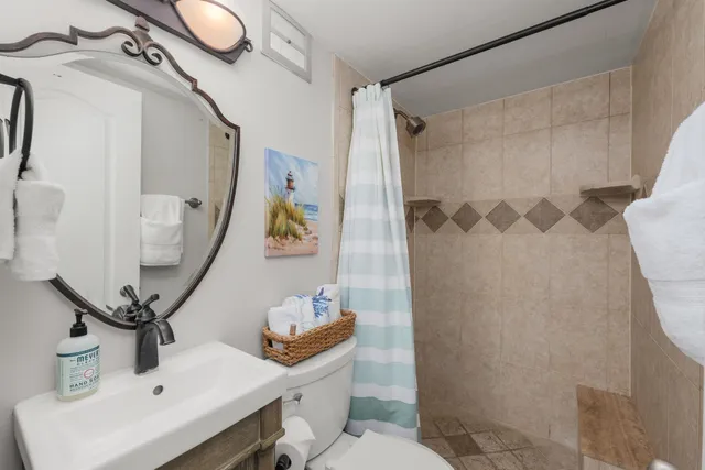 a bathroom with a sink mirror vanity and toilet