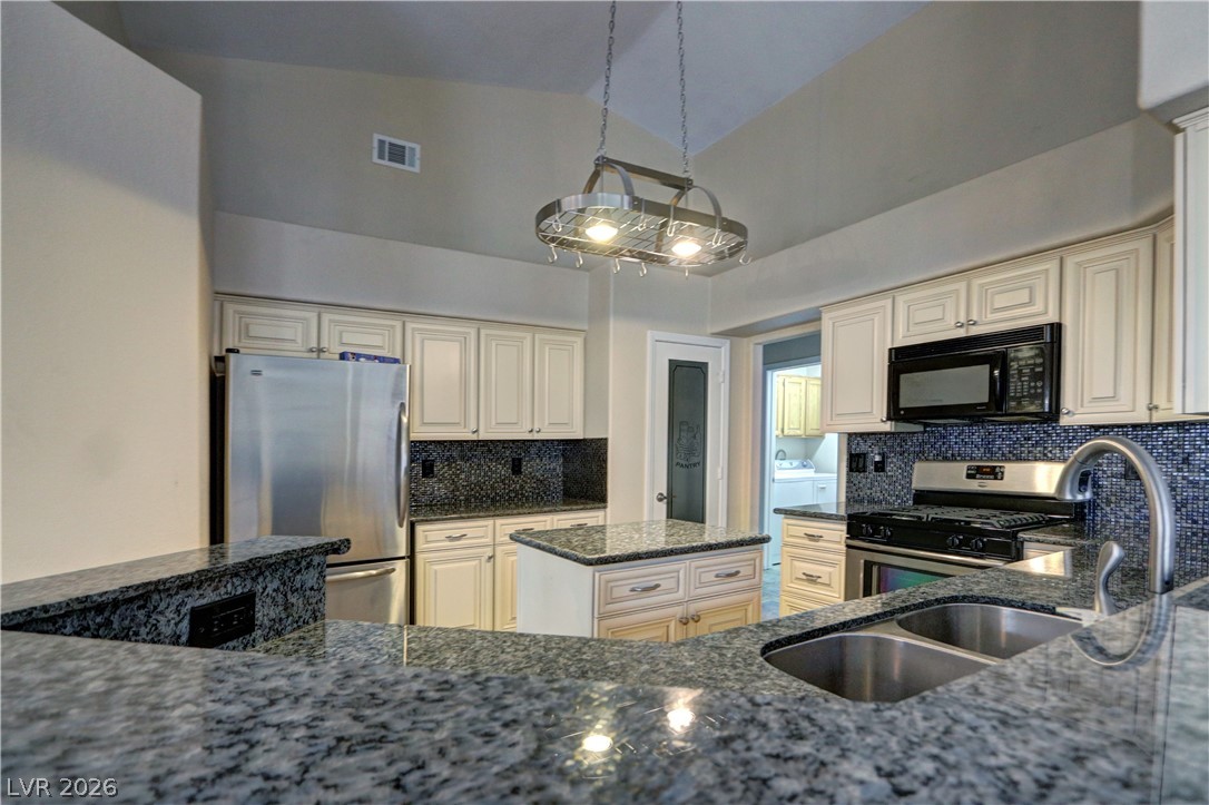 2108 Crestpoint Way Las Vegas, NV 89134 - Photo 11 of 27 An inviting kitchen features a central island, granite countertops, and modern appliances perfect for culinary adventures.