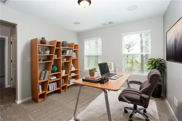 a view of a workspace with furniture and a window