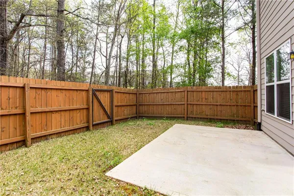 a view of backyard with wooden fence