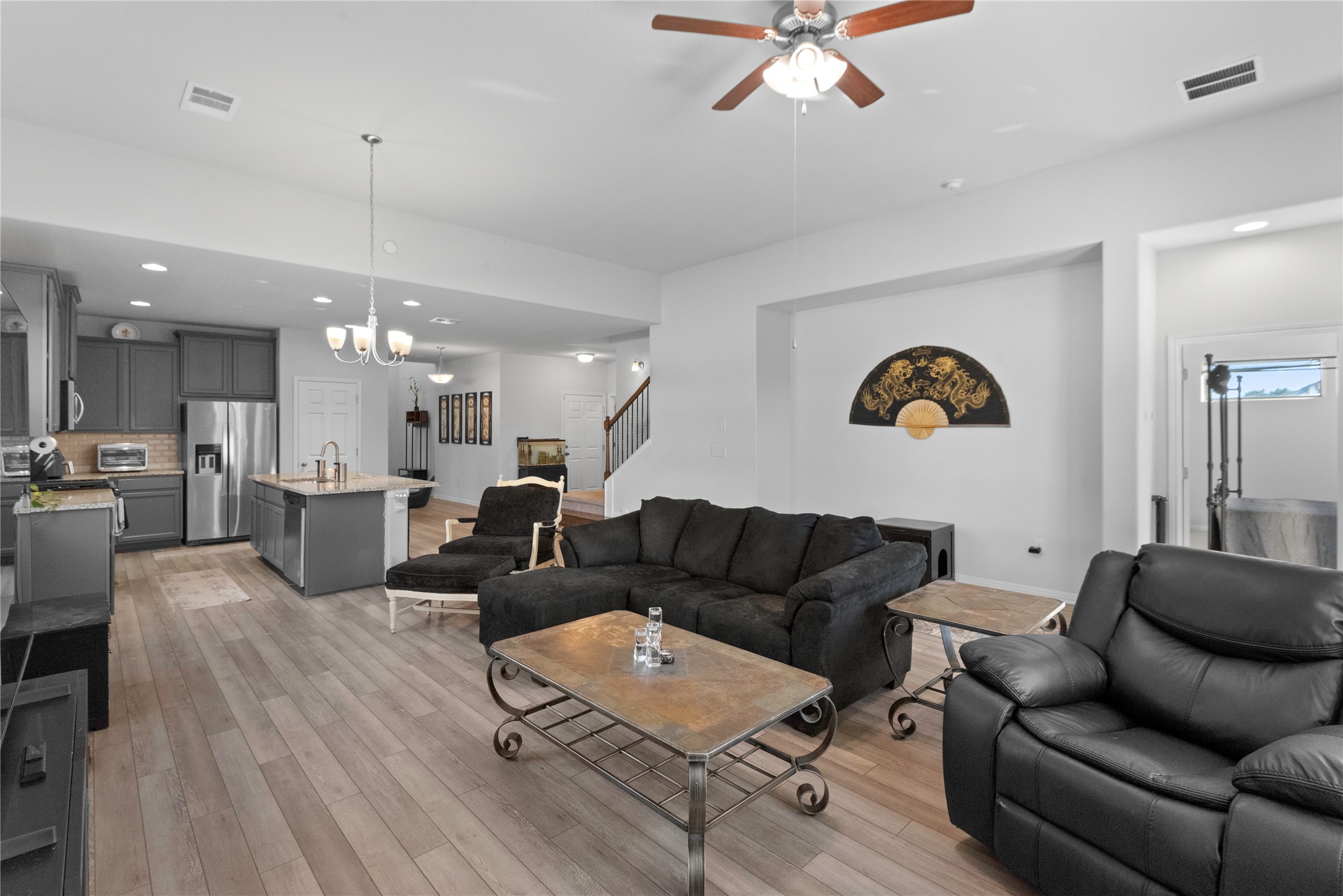 932 Medina Way Leander, TX 78641 - Photo 10 of 28 Living area featuring recessed lighting, a chandelier, light wood-style floors, a ceiling fan, and stairway