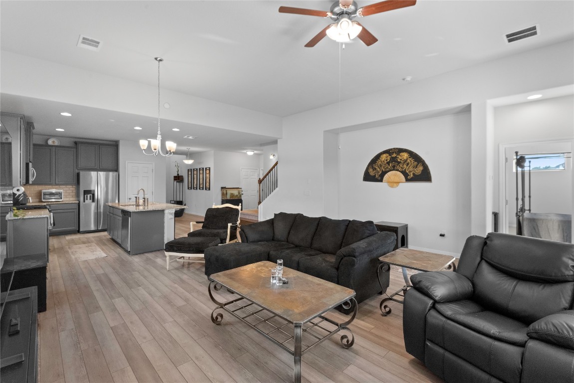 932 Medina Way Leander, TX 78641 - Photo 10 of 28 Living area featuring recessed lighting, a chandelier, light wood-style floors, a ceiling fan, and stairway