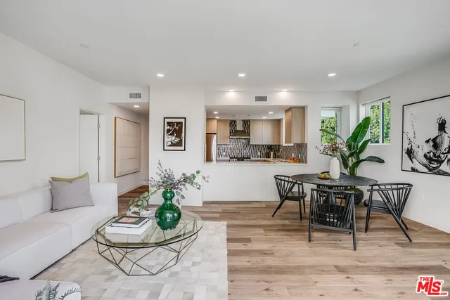 a living room with furniture kitchen and a potted plant