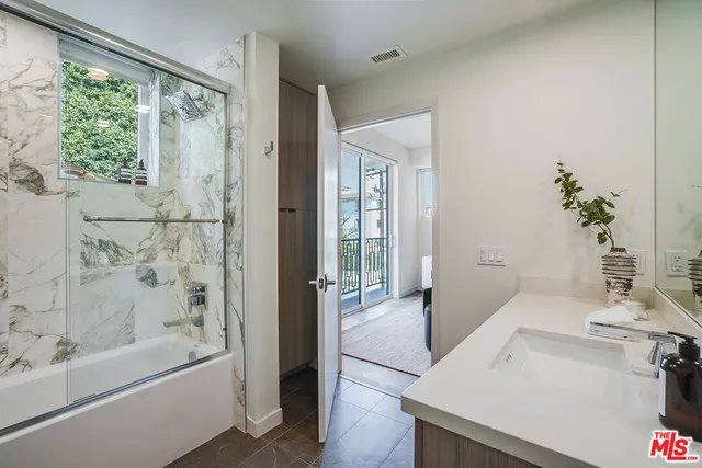 a bathroom with a tub sink and mirror