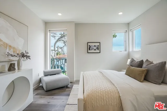 a bedroom with a large bed couch and a window