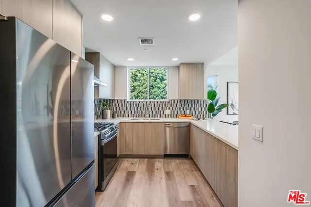 a kitchen with stainless steel appliances granite countertop a refrigerator and a sink