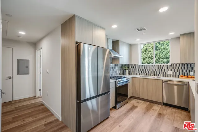 a kitchen with stainless steel appliances a refrigerator sink and microwave