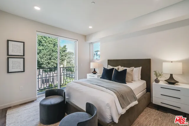 a bedroom with bed couch and window