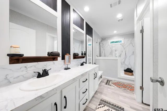 a bathroom with double vanity and a bathtub