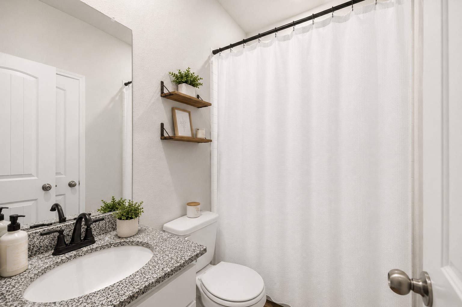 13432 Maverick Trail Road Conroe, TX 77303 - Photo 20 of 50 Charming 1st floor full bathroom featuring a sleek granite countertop, modern fixtures, and stylish floating shelves