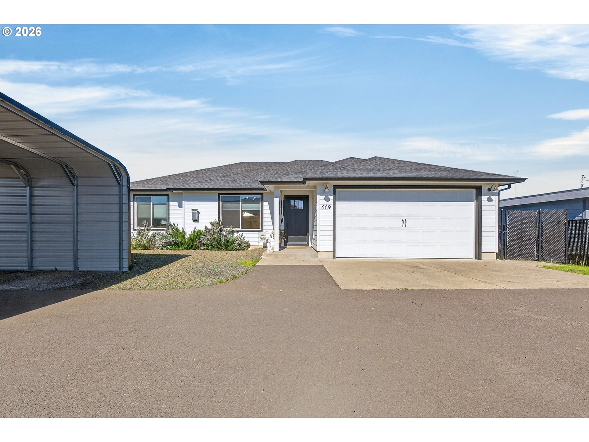 669 Northwest T Street Winston, OR 97496 - Photo 2 of 36 a front view of a house with a yard and garage