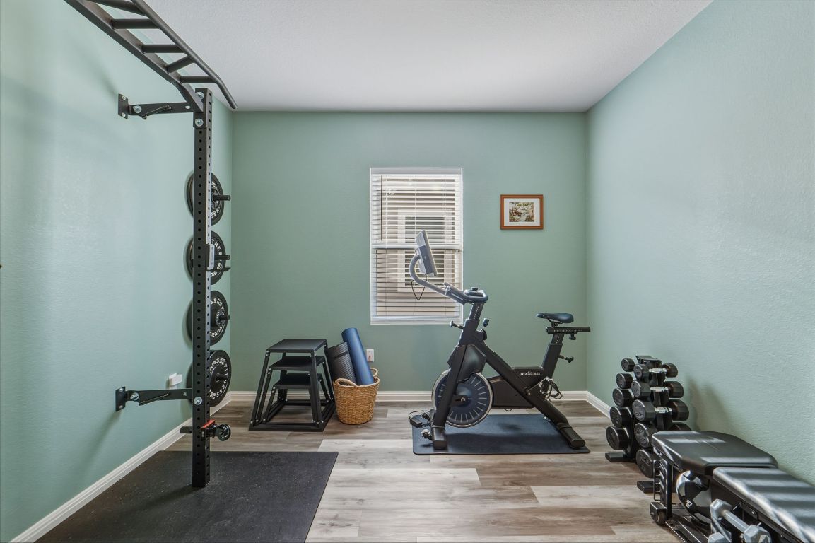 201 Wonderful Life Way Jarrell, TX 76537 - Photo 12 of 39 Main floor bedroom being used as an exercise area featuring wood finished floors.