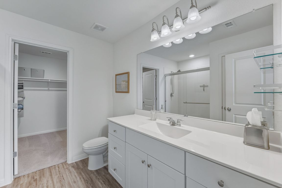 201 Wonderful Life Way Jarrell, TX 76537 - Photo 22 of 39 Ensuite bathroom with a walk in closet, vanity, a oversize shower stall, and light wood-style floors