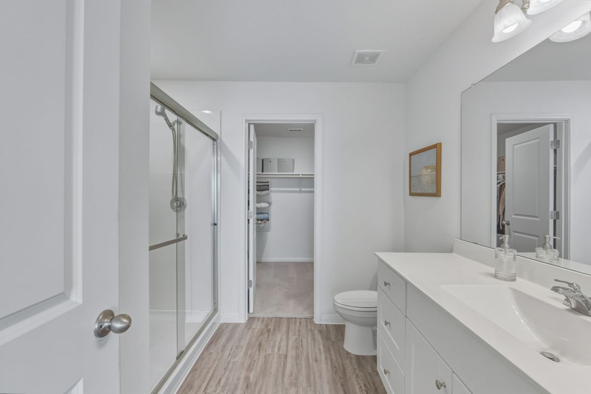 201 Wonderful Life Way Jarrell, TX 76537 - Photo 23 of 39 Ensuite bathroom with a walk in closet, vanity, a oversize shower stall, and light wood-style floors