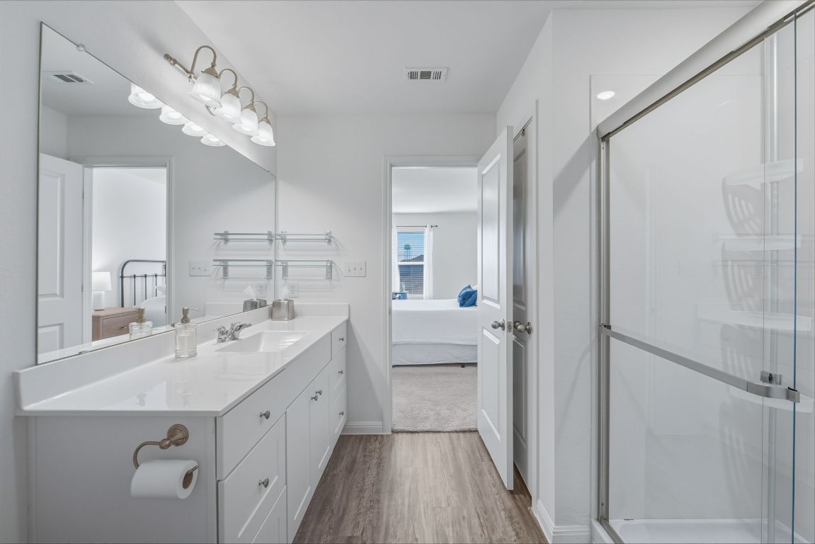 201 Wonderful Life Way Jarrell, TX 76537 - Photo 24 of 39 Ensuite bathroom with vanity, wood finished floors, and a stall shower