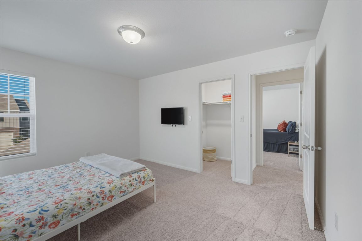 201 Wonderful Life Way Jarrell, TX 76537 - Photo 27 of 39 Bedroom - two of 4 located on upper floor with light carpet. Walk in closet.