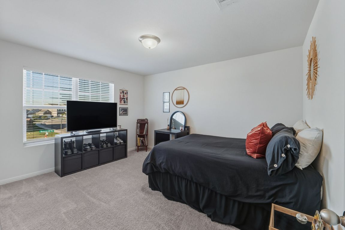 201 Wonderful Life Way Jarrell, TX 76537 - Photo 29 of 39 Bedroom - three of four located on upper floor with light carpet. Walk in closet.