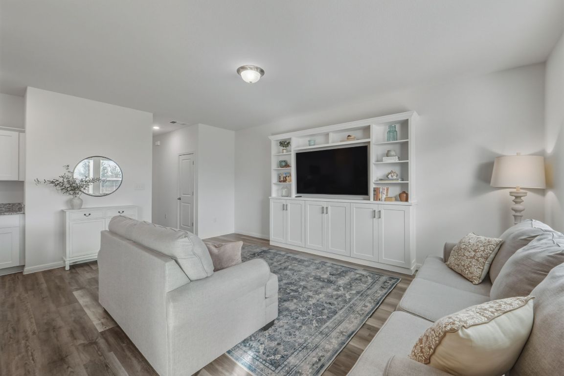 201 Wonderful Life Way Jarrell, TX 76537 - Photo 6 of 39 Living area with a custom made built in entertainment center. Plenty of storage & shelves to display your decorative items. The TV & wall mount convey. Faux wood flooring.