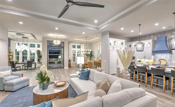 a living room with furniture kitchen view and a large window