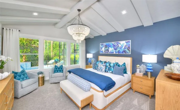 a bedroom with a large bed and a chandelier