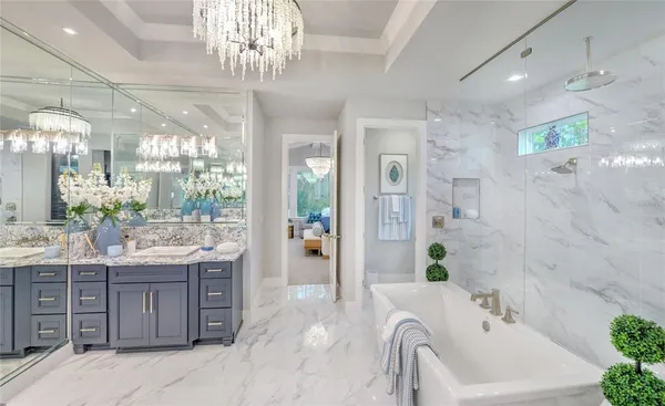 a spacious bathroom with a granite countertop sink a large mirror and shower