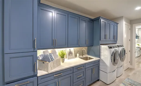 a utility room with wooden floor washer and dryer