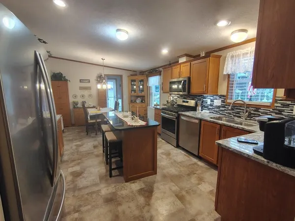 a kitchen with stainless steel appliances granite countertop a refrigerator and a cabinets