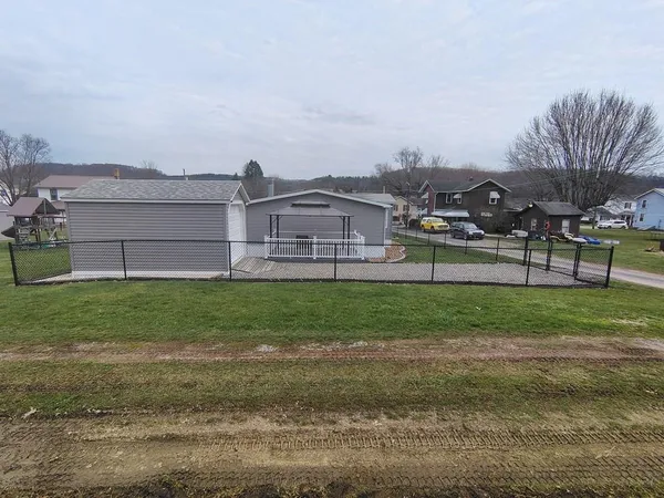 a view of a big house with a big yard and large trees