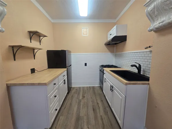 a kitchen with granite countertop a sink and a stove top oven