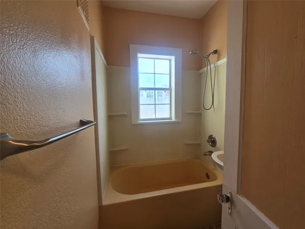 a bathroom with a tub and a window