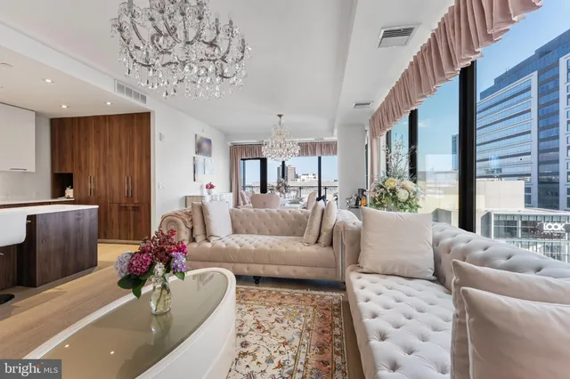 a living room with furniture and a chandelier