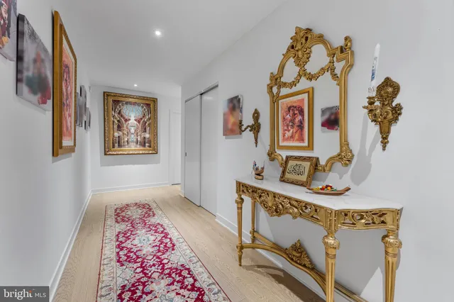 a view of a hallway with workspace and bedroom with furniture