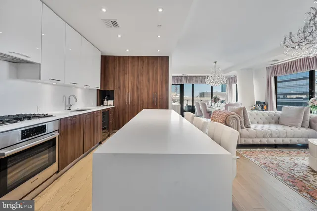 a kitchen with stainless steel appliances kitchen island granite countertop a table chairs sink and cabinets