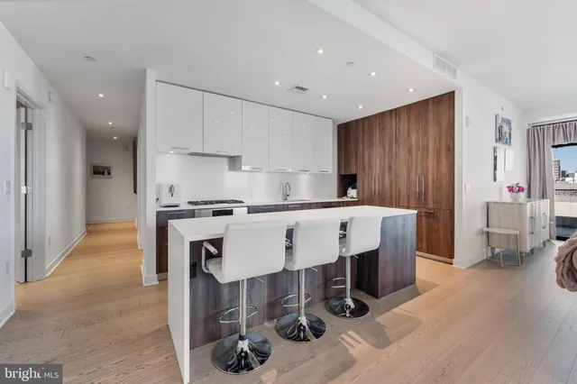 a kitchen with stainless steel appliances kitchen island granite countertop a refrigerator and a stove top oven