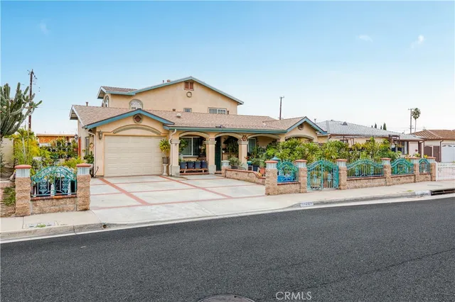 a front view of a house with a yard and potted plants